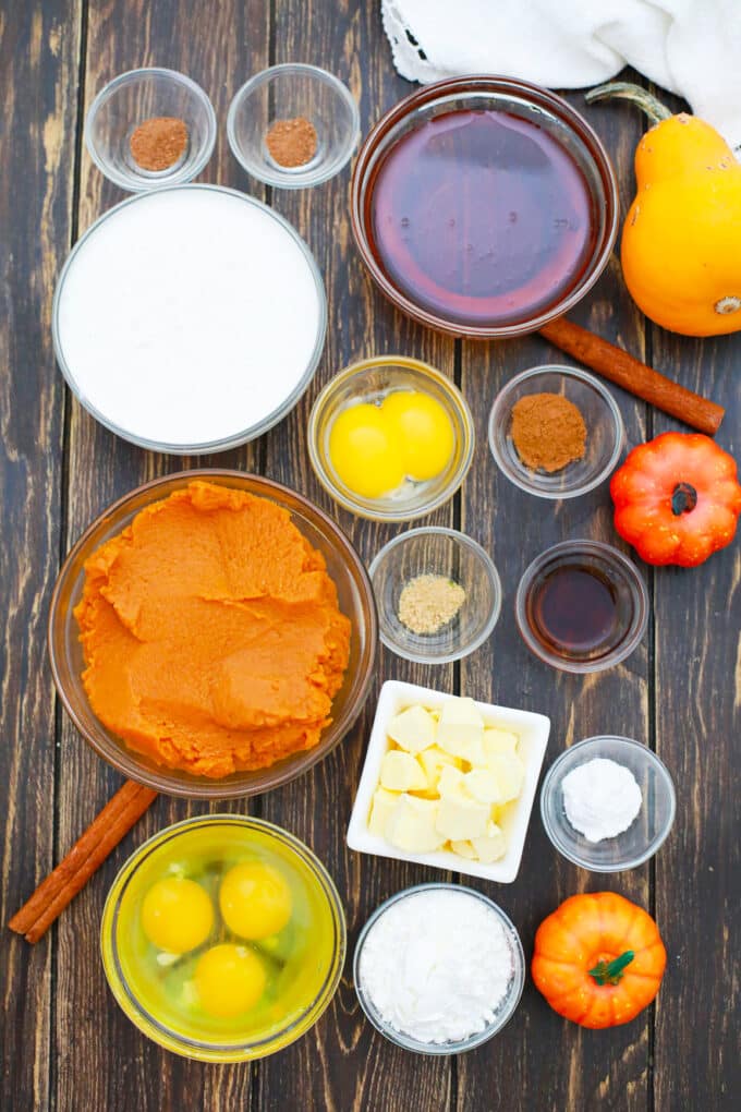Overhead shot of gluten-free creamy crustless pumpkin pie ingredients on a wooden table.