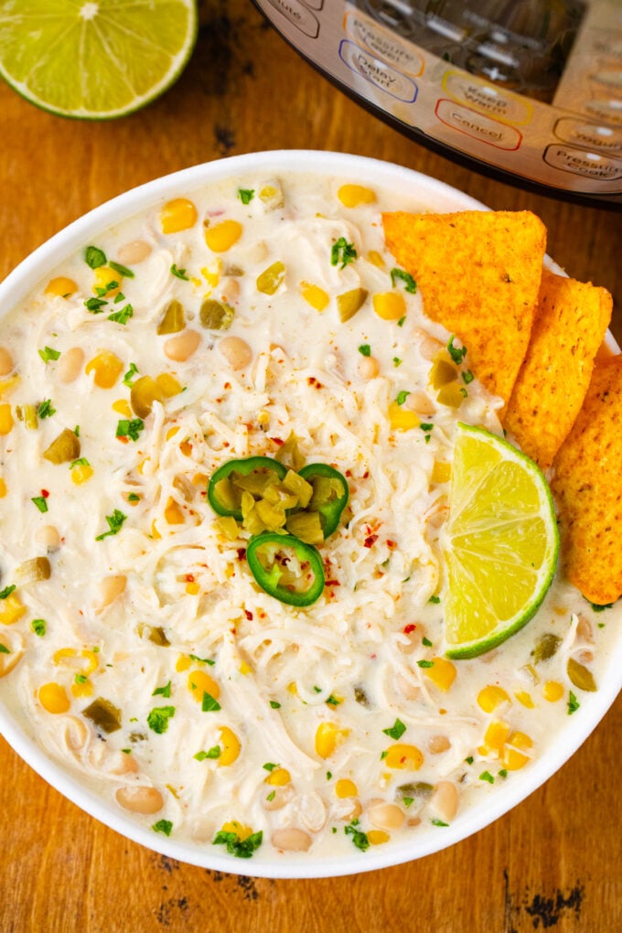 Homemade Instant Pot white chicken chili with corn chips and jalapenos.