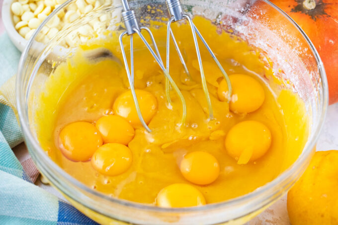 Whisk eggs and egg yolks into pumpkin cake batter.