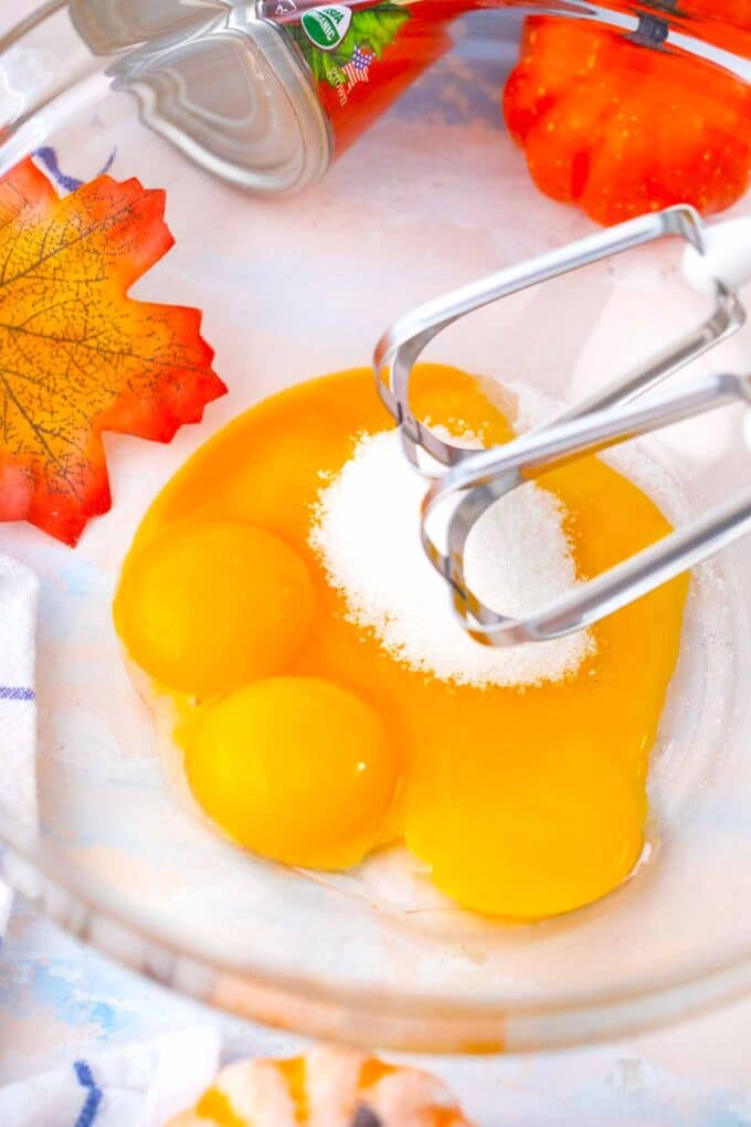 whisking egg yolks and sugar in a bowl