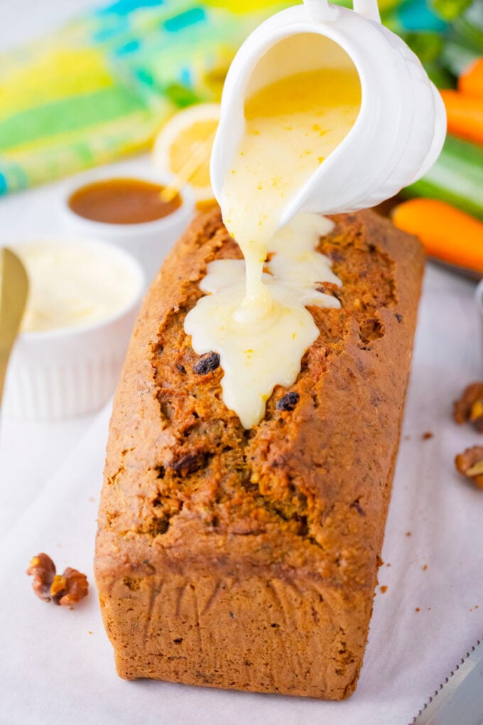 Pouring lemon glaze over carrot zucchini bread.