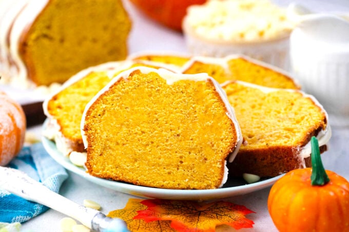 Slices of glazed pumpkin pound cake on a plate.