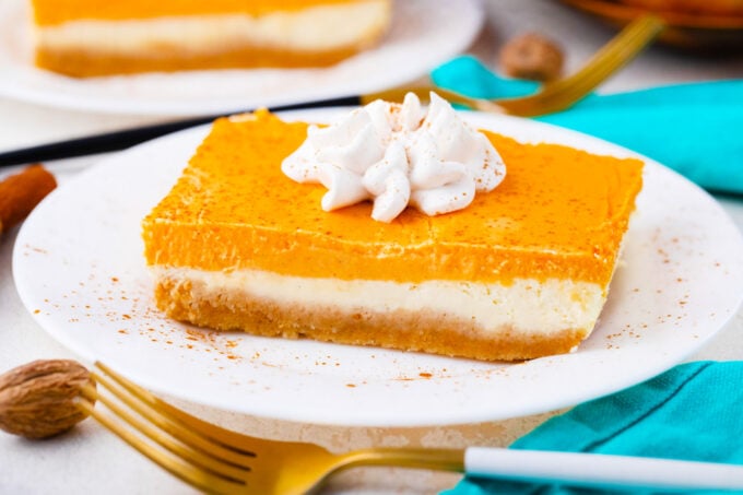 Sweet potato cheesecake bars topped with whipped cream.
