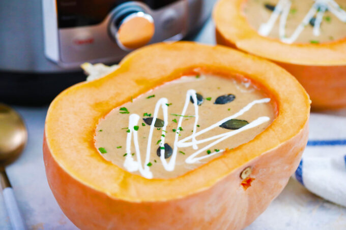 Creamy instant pot pumpkin soup in a carved pumpkin.