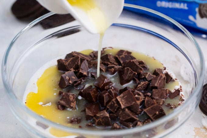 Mixing chopped chocolate and melted butter in a bowl.