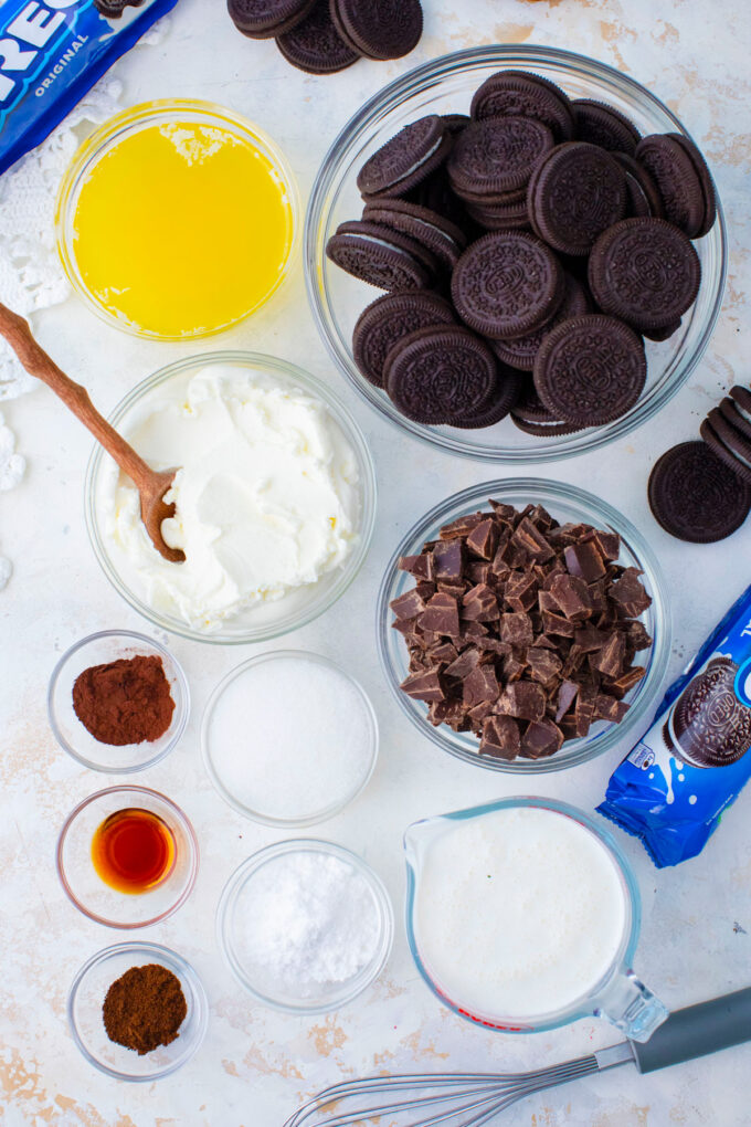 Overhead shot of no bake chocolate pie ingredients in bowls on a light surface.