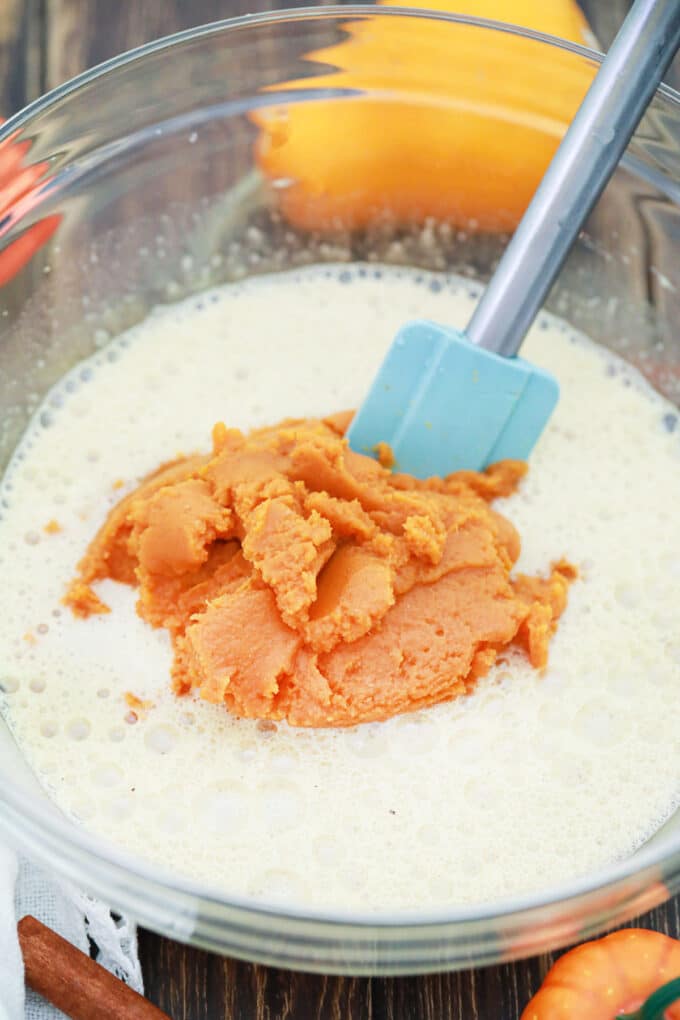 Mixing pumpkin puree into beaten eggs.