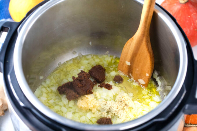 Sautéing garlic, onion, ginger, and curry in the Instant Pot.
