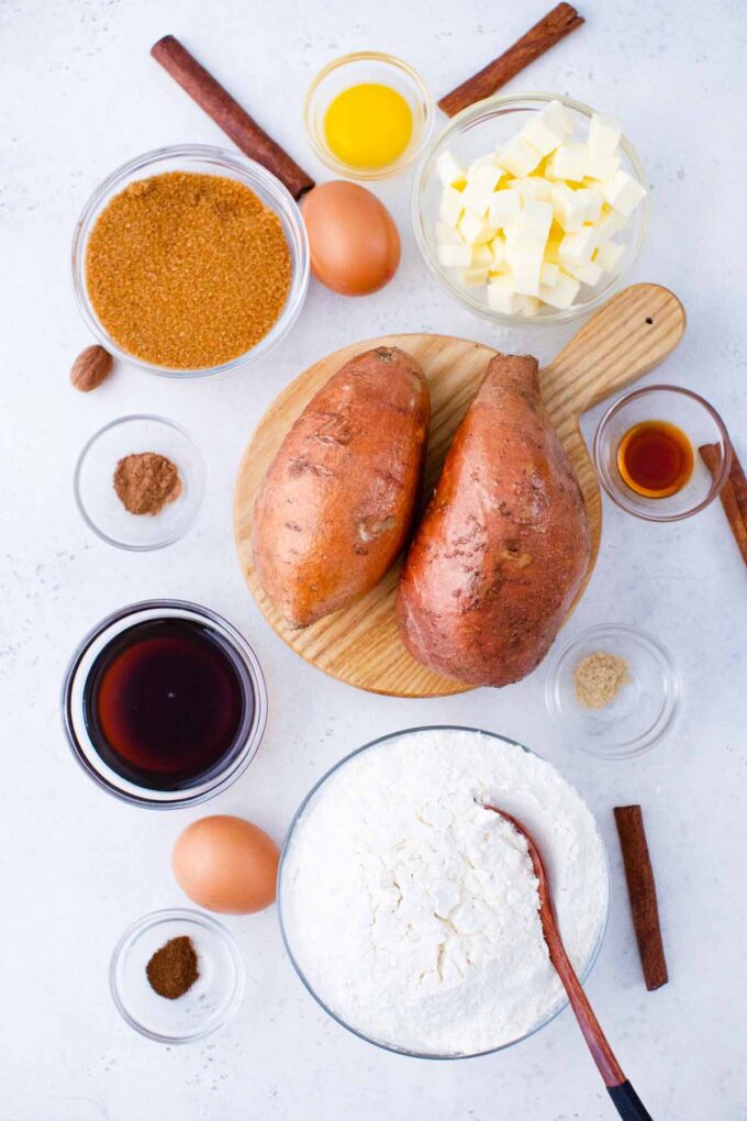 sweet potato pie ingredients arranged in bowls on a light surface