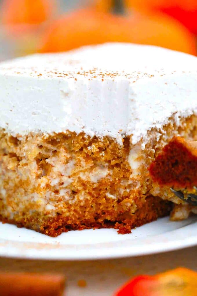 a forkful of tres leches pumpkin cake with maple whipped cream