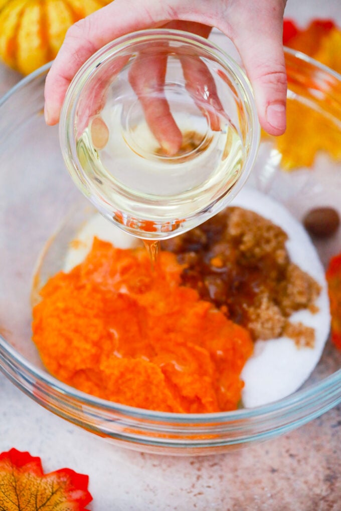 Mixing wet ingredients for tres leches pumpkin cake.