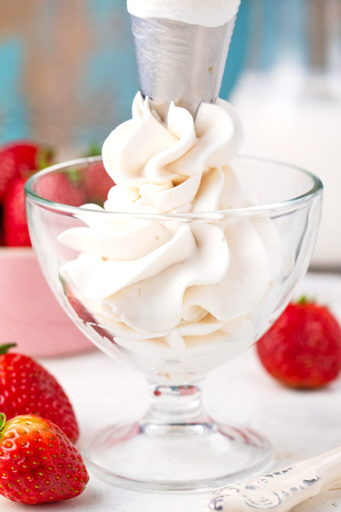 Piping homemade whipped cream into an ice cream bowl.