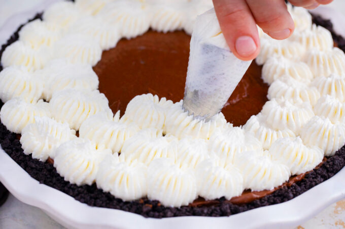 Topping no bake chocolate pie with whipped cream.