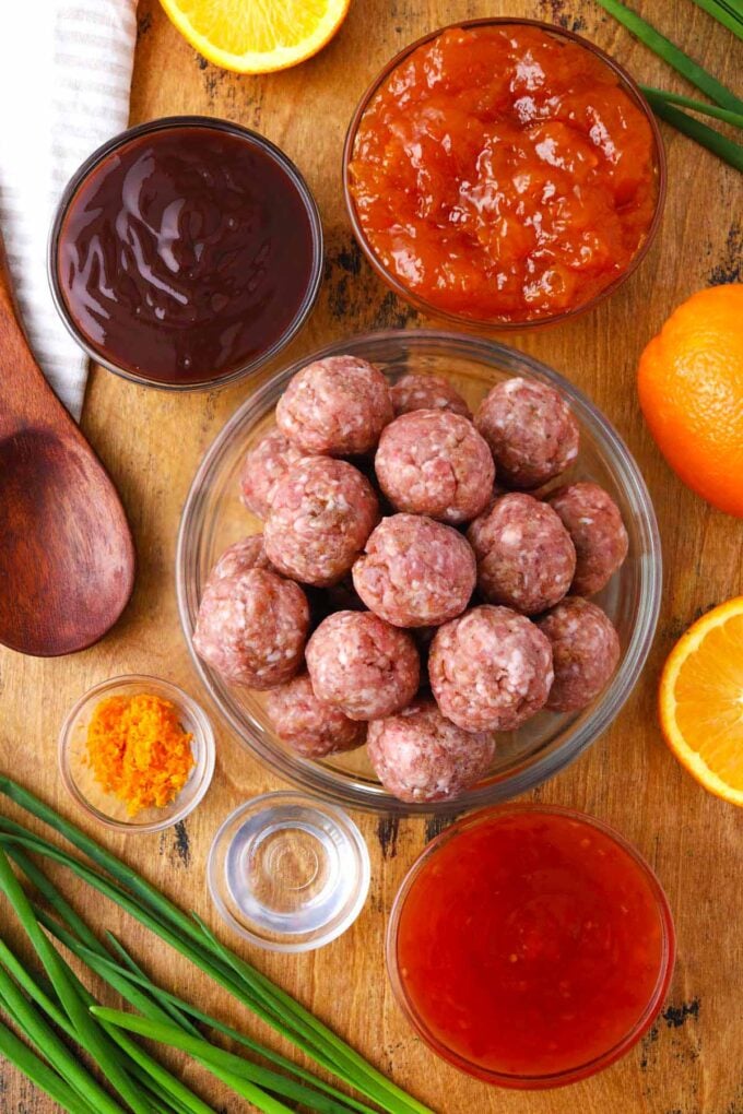 Overhead shot of BBQ crockpot meatballs ingredients in bowls on a table.