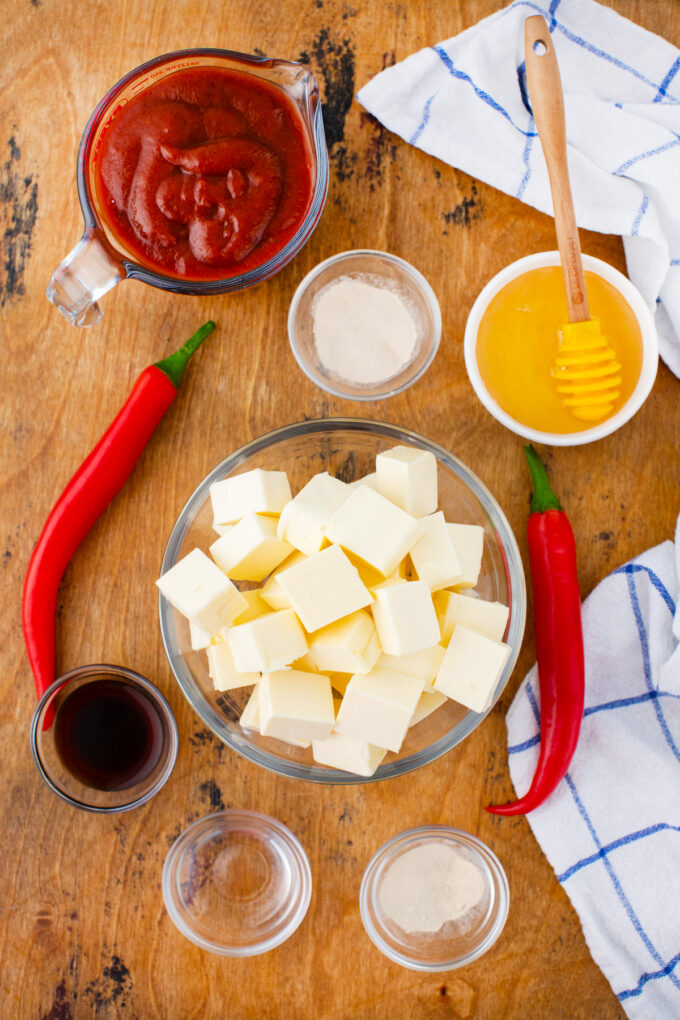 Overhead shot of Buffalo sauce ingredients in bowls on a wooden table.