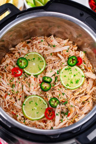 Overhead shot of Instant Pot salsa chicken with lime and jalapenos.