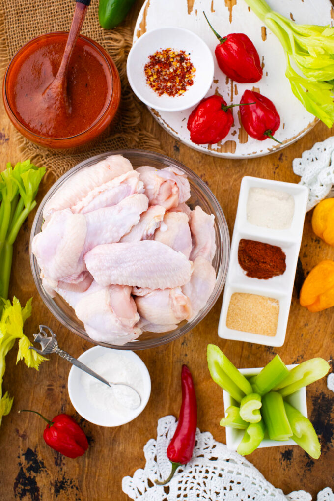 Homemade baked Buffalo chicken wings ingredients arranged on a wooden table.