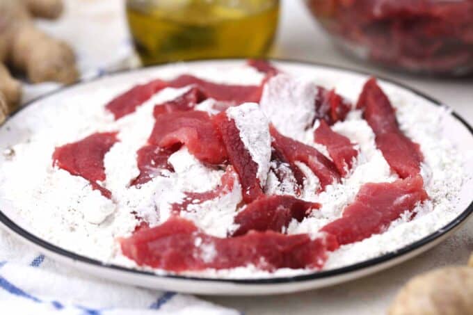 Coat flank steak slices in cornstarch.