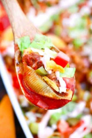 close macro shot of cheeseburger stuffed shells on a wooden spoon