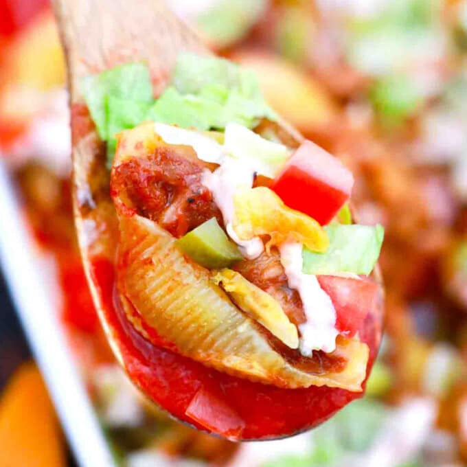 close macro shot of cheeseburger stuffed shells on a wooden spoon