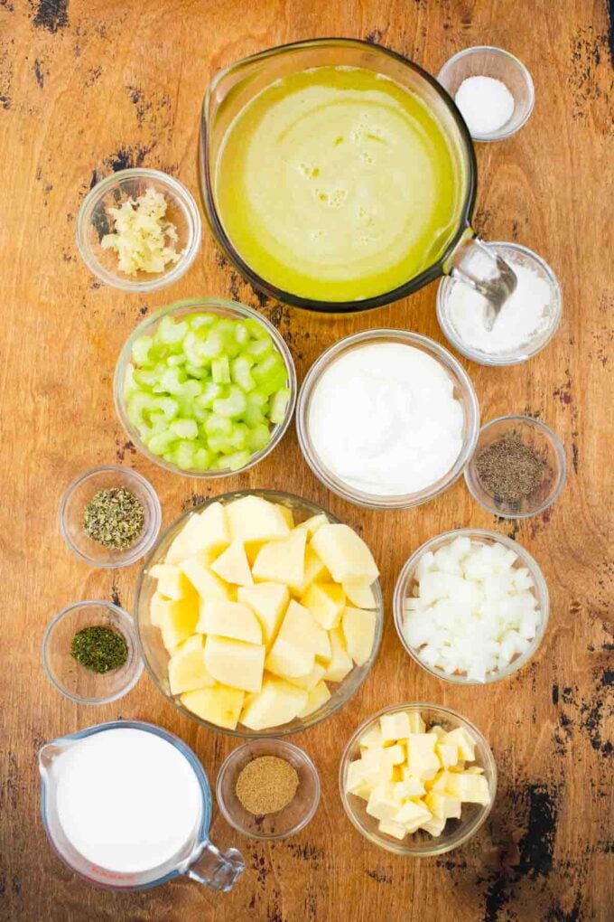 crockpot cheesy potato soup ingredients in bowls on a wooden table