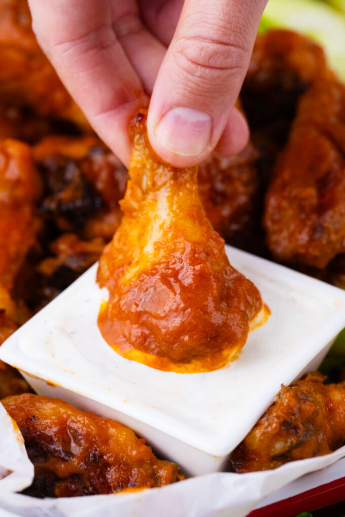 Dipping baked Buffalo chicken wings into Ranch.