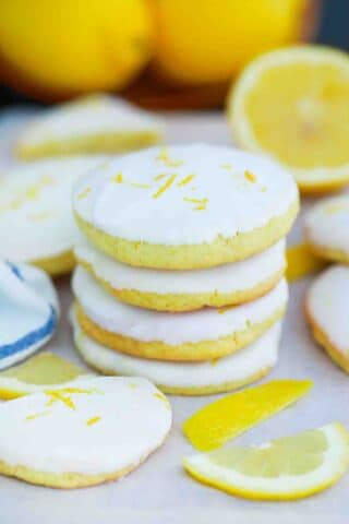 stacked homemade girl scout lemon cookies with lemon in the background