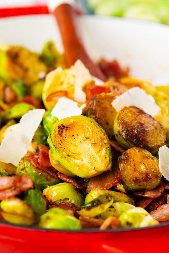 A pan of Brussels sprouts with bacon and shaved parmesan cheese.