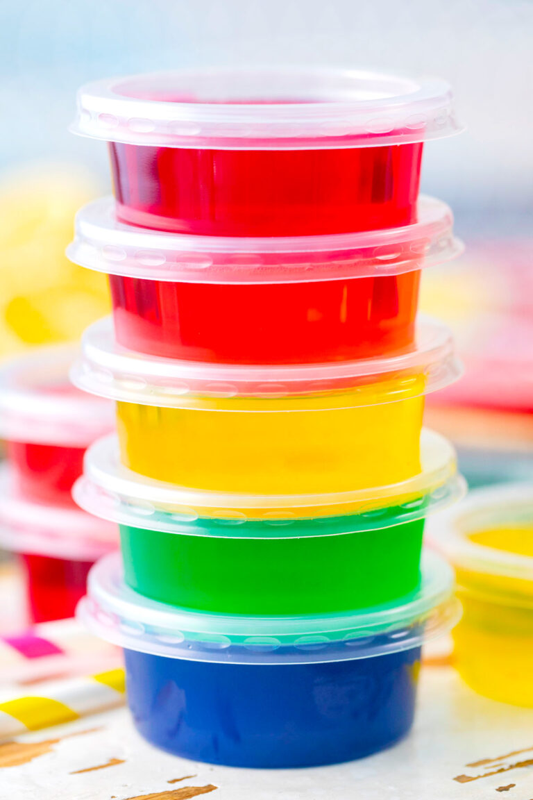 A stack of rainbow jello shots in a variety of colors.