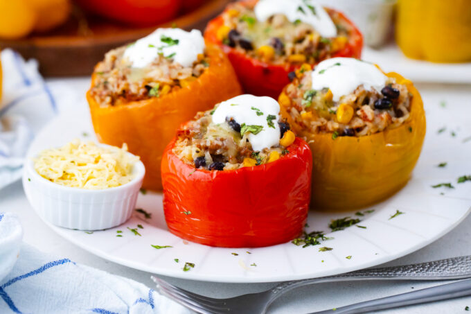 Homemade slow cooker Mexican stuffed peppers topped with cheese and sour cream.
