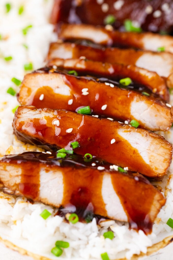 Sliced slow cooker teriyaki pork chops over rice.