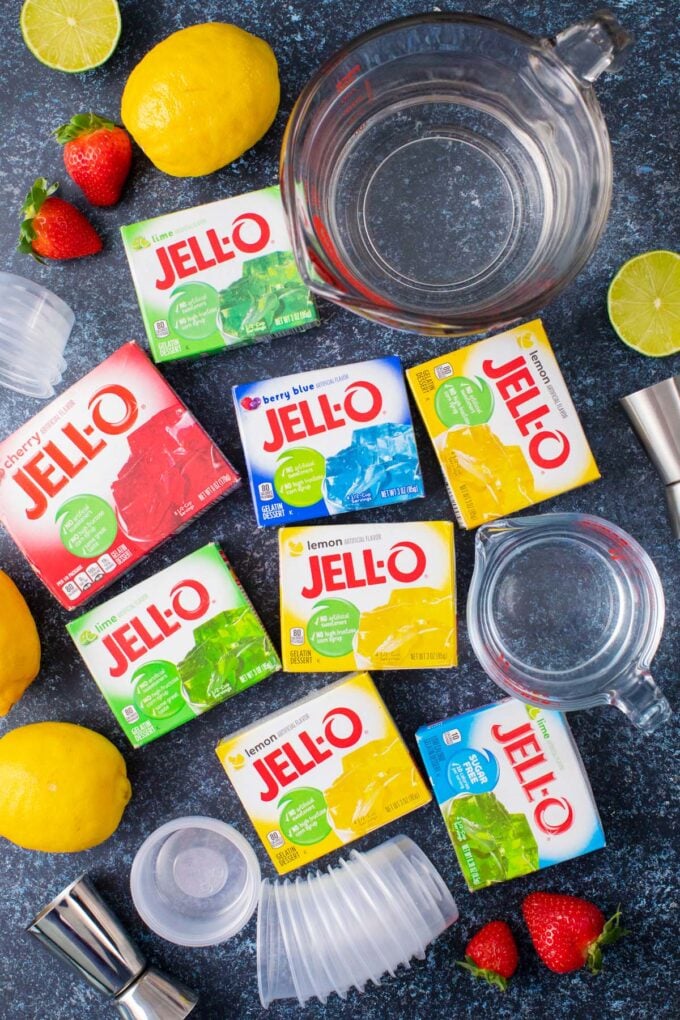 Homemade jello shots ingredients on a dark surafce.
