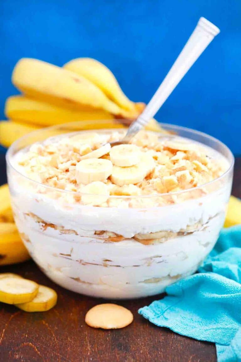 a bowl of homemade magnolia bakery banana pudding with bananas in the background