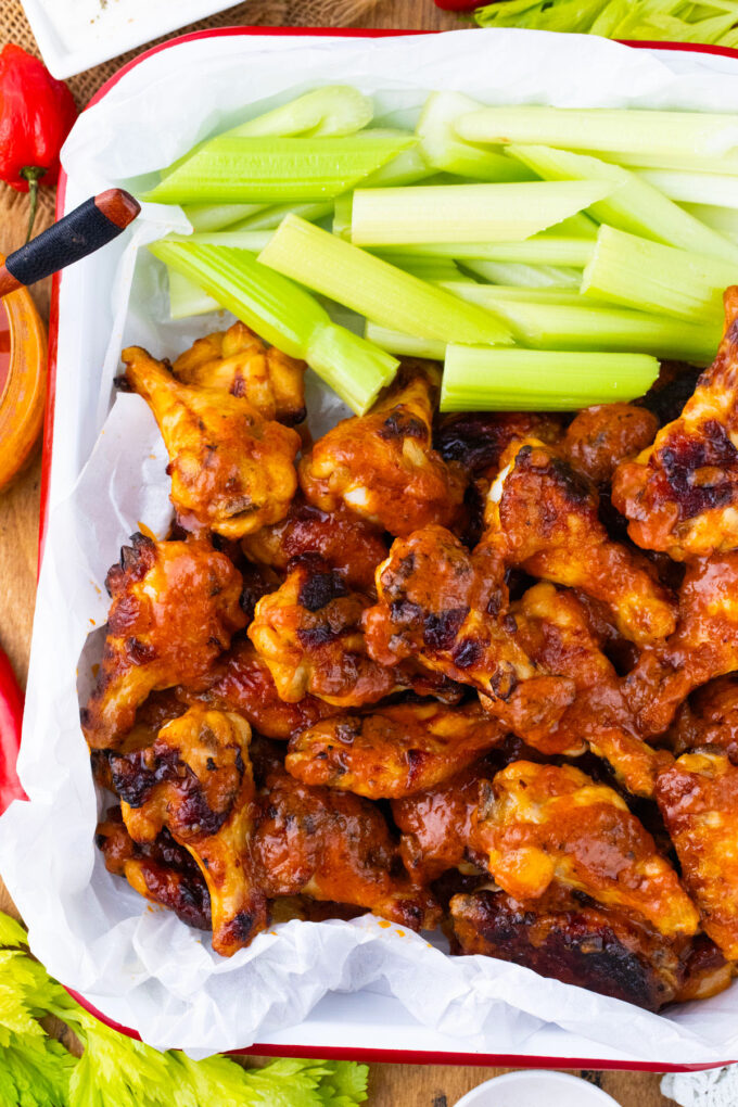 Overhead shot of baked Buffalo chicken wings served with celery sticks.