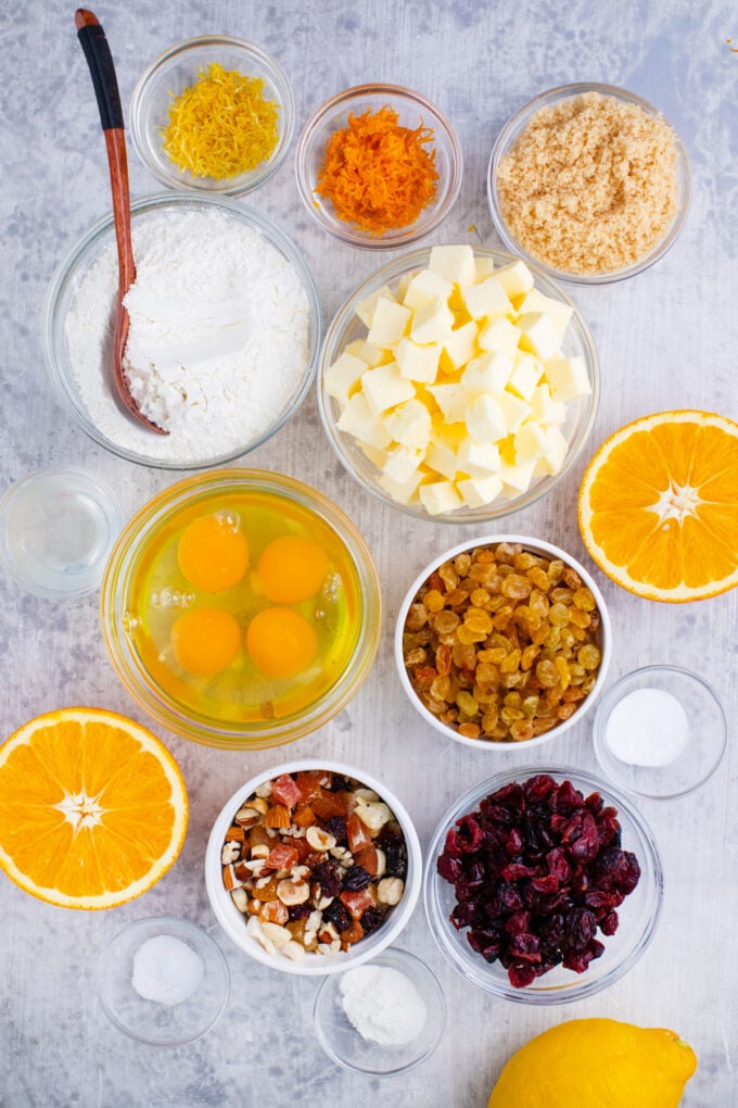 Overhead shot of Simnel cake ingredients in bowls on a white surface.