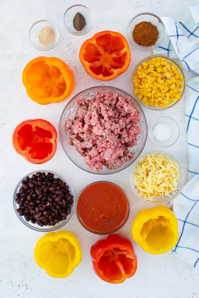 Overhead shot of slow cooker Mexican stuffed peppers ingredients in bowls on a table.