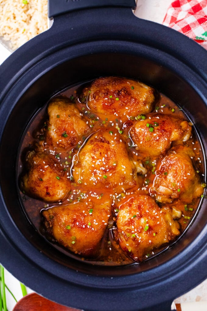Overhead shot of chicken thighs in brown sugar garlic sauce in the slow cooker.