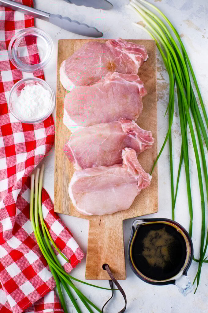 Overhead shot of slow cooker teriyaki pork chops recipe ingredients on a white surface.