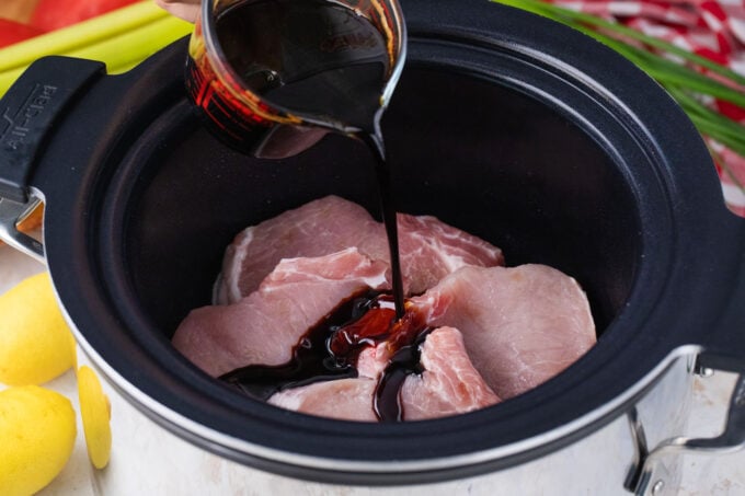 Pouring teriyaki sauce over pork chops.