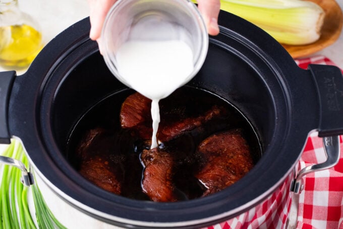 Adding cornstarch slurry to slow cooker pork chops with teriyaki sauce..