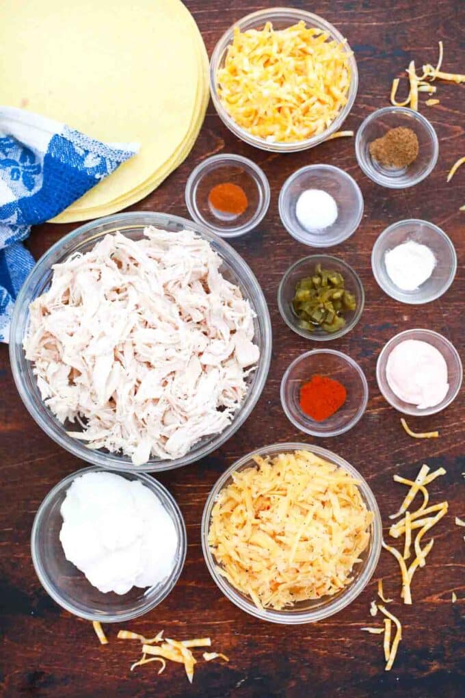overhead shot of shredded chicken spices cheese sour cream on a table