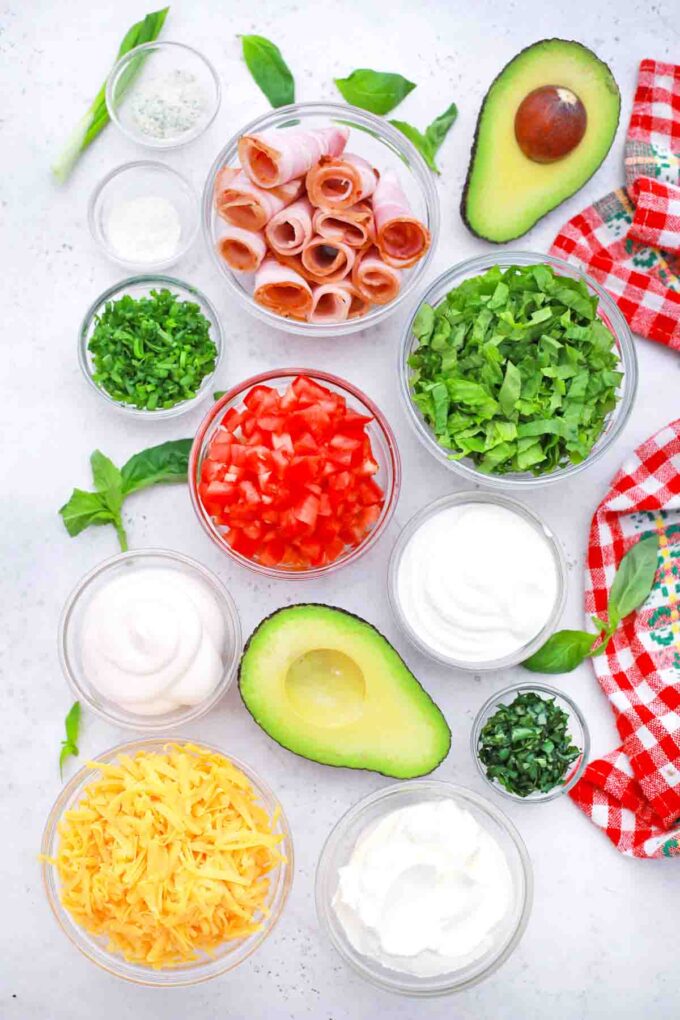 overhead shot of bacon veggies cheese mayo cream cheese in bowls on a table