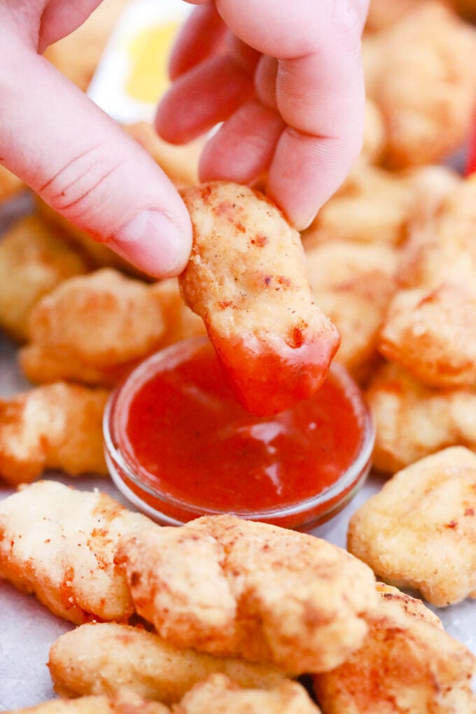 Dipping McDonald's Chicken Nuggets Copycat recipe in ketchup.