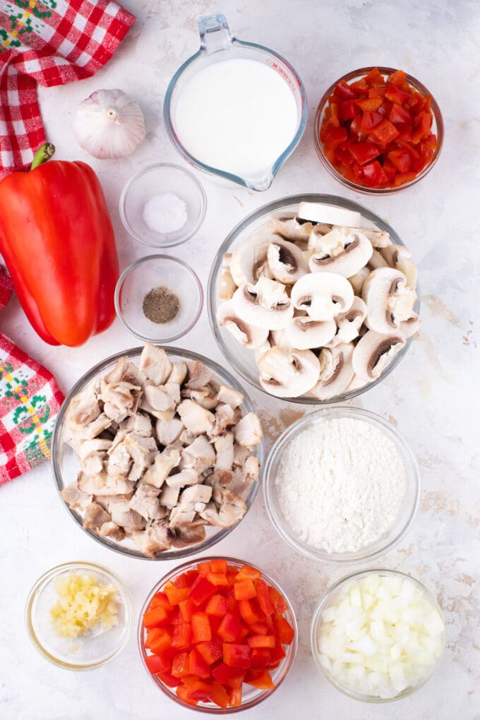 Overhead shot of chicken a la king ingredients in bowls on a table.