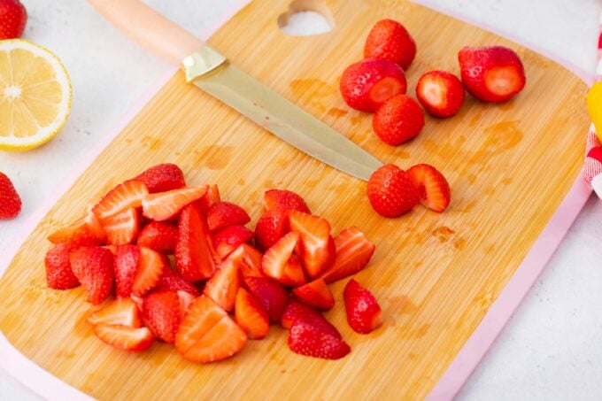 Slicing strawberries on a cutting board.