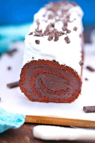 close shot of french silk cake roll topped with whipped cream and chocolate shavings