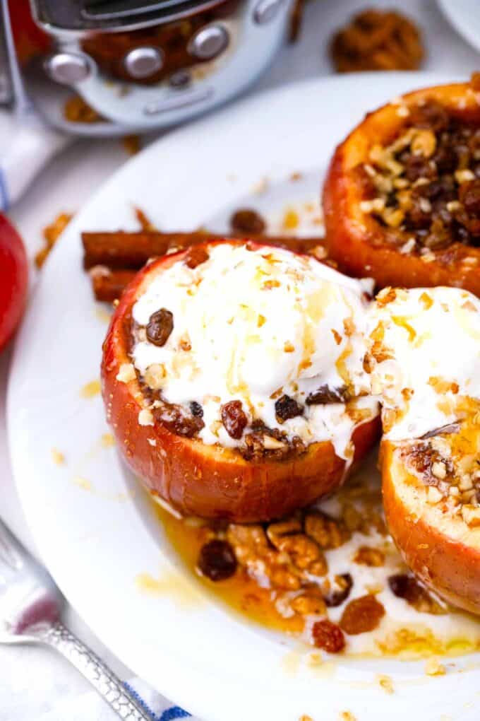 slow cooker baked apples on a plate, topped with vanilla ice cream