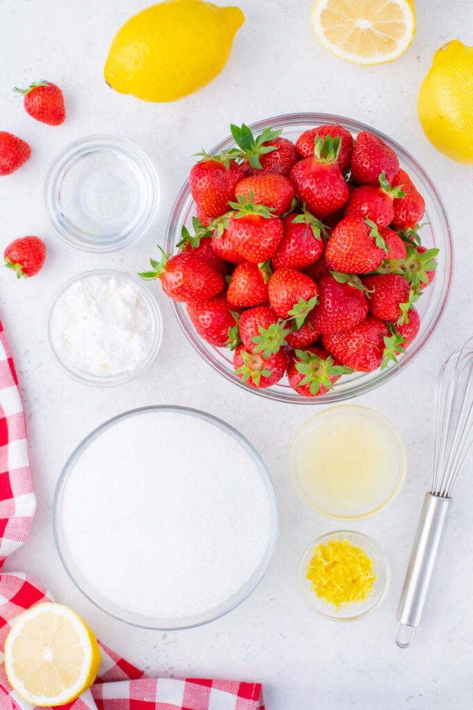 Overhead shot of instant pot strawberry jam ingredients in bowls on a table.