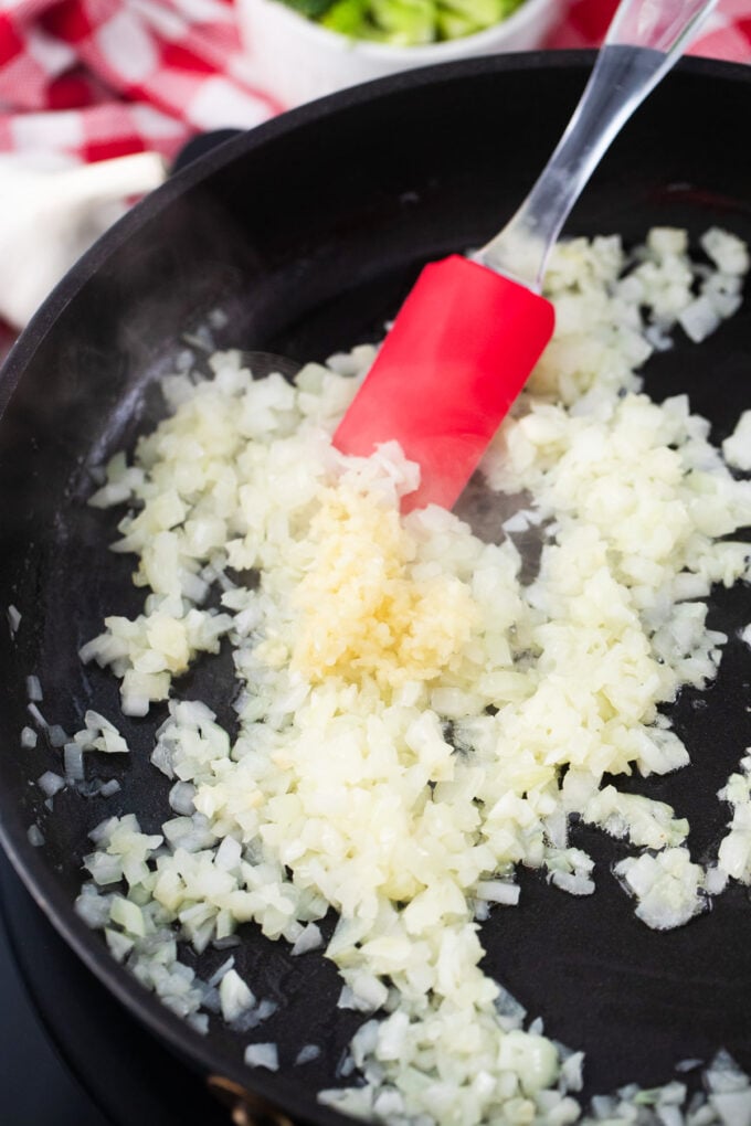Sautéing onions and garlic in a pan.