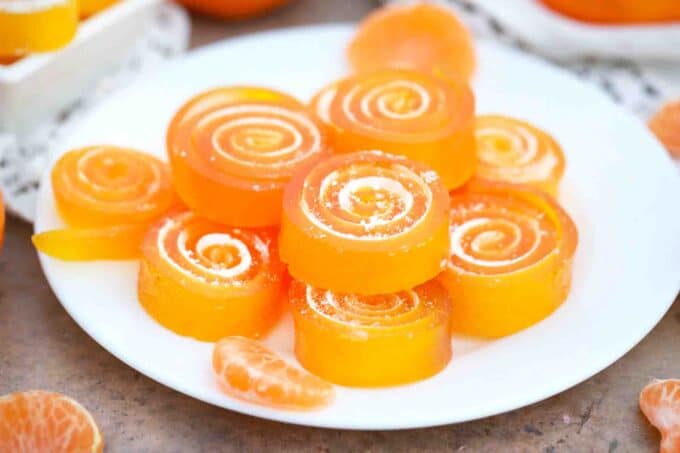 orange jelly candy slices stacked on a plate